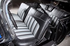 the interior of an old car with black and white striped leather upholstered seats