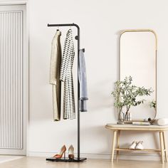 a coat rack with two coats hanging on it next to a stool and mirror in a room