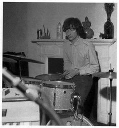 the man is playing drums in his living room