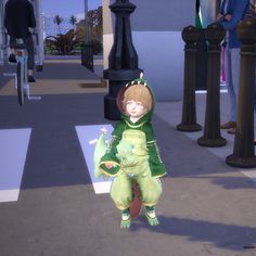 a little boy in a green outfit is standing on the sidewalk