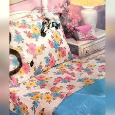 a bed with flowers on it next to a lamp