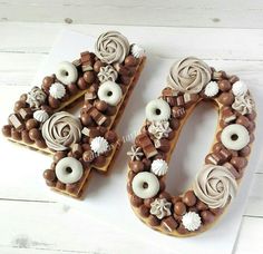 the letter o is made out of cookies and decorated with icing, chocolates and seashells