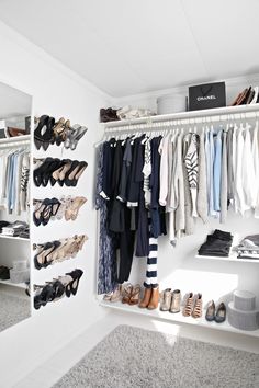 a closet filled with lots of different types of shoes and clothes hanging on the wall