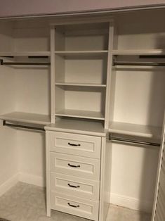 an empty walk in closet with drawers and shelves