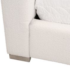 the back end of a white couch with a quilted cover on it's arm