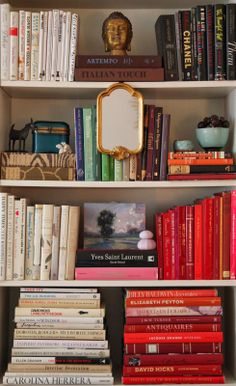 a book shelf filled with lots of books next to a mirror and other items on top of it