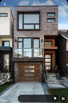 a modern house with two garages and stairs leading up to the second story door