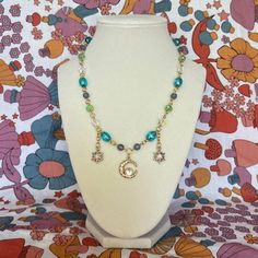 A pretty handmade gold, blue, and green necklace with a moon pendant. Has a lobster clasp. I am a 21y/o queer & autistic artist from Tennessee. I make all of my art at home, by hand. Time and care go into each piece, and I am incredibly grateful to anyone who wants to support my art! - To see more of my work, visit my Instagram pages @girlcritter & @girlcritterjewelry Handmade Celestial Beaded Necklaces As Gift, Handmade Celestial Beaded Necklace For Gift, Handmade Blue Celestial Necklace, Handmade Multicolor Celestial Necklace, Handmade Green Spiritual Charm Necklaces, Handmade Gold, Green Necklace, Moon Pendant, Handmade Necklaces