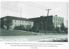 an old black and white photo of some buildings with graffiti on the side of it