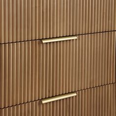 a wooden dresser with two brass handles on it