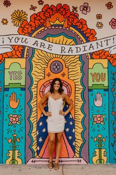 a woman standing in front of a colorful wall