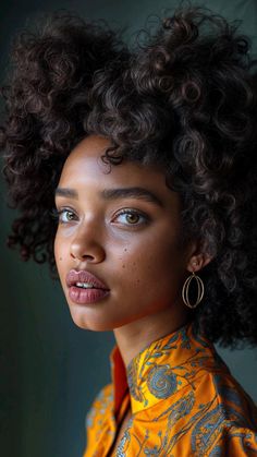 a young woman with curly hair and blue eyes wearing an orange top looking off to the side