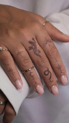 two people with tattoos on their fingers, one is holding the other's hand