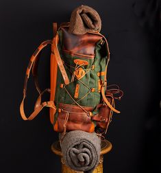 a green and brown backpack sitting on top of a stool