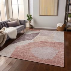 a living room area with a couch, chair and rug on the hardwood flooring