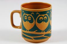 a coffee cup with two owls painted on the outside and inside, sitting in front of a white background