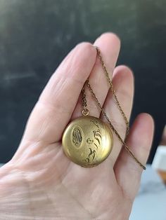 This is a vintage 12K yellow gold filled photo locket pendant necklace. There are initials etched on the front of the locket, but I can not decipher what the letters are. A few light surface scratches and slight discoloration consistent with age. Hallmarks: 1/20-12KT Weighs: 9 grams 18" long and pendant measures 1 3/8" tall with bale and 1 1/16" wide All measurements are approximate. Condition: Vintage condition. Normal wear associated age. Please see photos. Sold as is. Priced accordingly. Please look over carefully and inspect any and all photos. Our shop is committed to fully disclosing all items' conditions and history with as great of detail as possible. Please keep in mind; what constitutes as new or unused condition for older era jewelry differs from non-vintage pieces; please consi Vintage 14k Gold Engraved Locket Necklace, Vintage Charm Oval Pendant Locket Necklace In Brass, Vintage Gold Etched Locket Necklace, Vintage Bronze Brass Locket Necklace, Gold-tone Brass Locket Necklace, Locket Pendant Necklace, Kraft Gift Boxes, Photo Locket, Locket Necklace