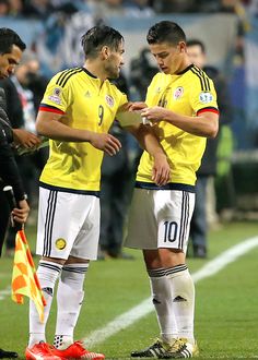 two soccer players standing next to each other on a field