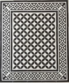 a black and white tile design with an intricate pattern in the center, on top of a tiled floor