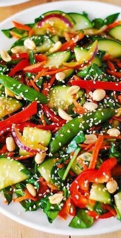 a white plate topped with vegetables and sesame seeds