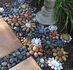 there are many different colored rocks in the ground next to a flower pot and planter