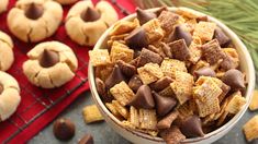 a bowl filled with chocolate chip cheetos next to some cookies and pine cones