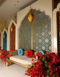 an elaborately decorated room with red flowers and gold accents on the walls, along with decorative wall hangings