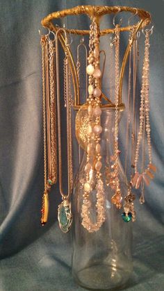 a glass vase filled with lots of beads and chains hanging from it's side