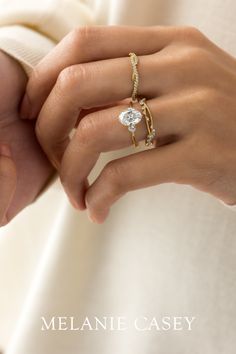 a close up of a person's hand holding an engagement ring