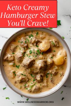 a bowl filled with meat and potatoes covered in gravy on top of a marble counter