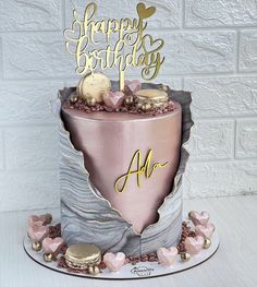 a birthday cake with pink frosting and gold decorations