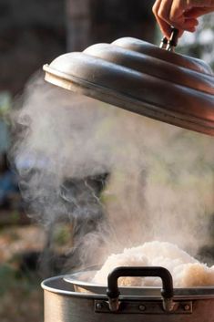 a person is cooking food in a pot with steam coming from the bottom and on top