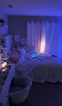 a laptop computer sitting on top of a bed in a room with candles and lights