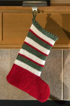 a knitted christmas stocking hanging from a door handle on a kitchen stove top