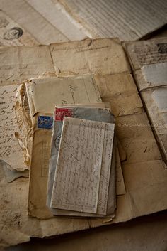 several old letters and envelopes on top of each other, all covered in paper