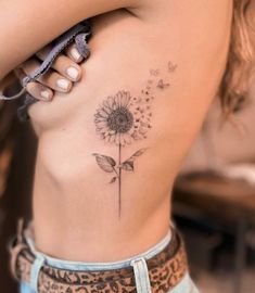 a woman's stomach with a flower tattoo on it