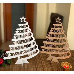 two wooden christmas trees sitting on top of a table