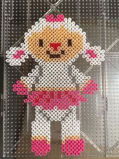 a cross - stitch doll is displayed on a clear plastic case with holes in it