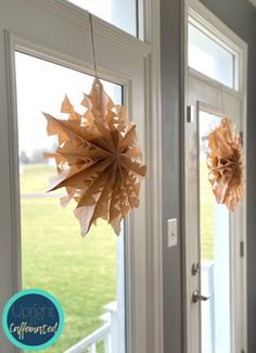 two brown paper balls hanging from the side of a door with grass in the background