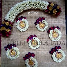 an arrangement of white and red flowers with gold accents on a tablecloth, surrounded by other decorations