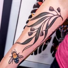 a woman's arm with a tattoo on it that has a flower and a bee