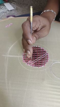 a person is drawing on a piece of fabric