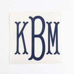 a sticker with the letter k b m in blue ink on a white background