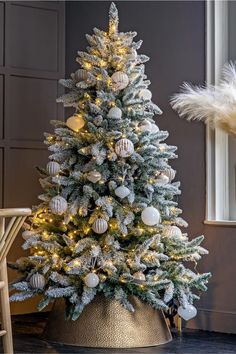 a white christmas tree in a gold pot