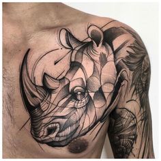 a man's chest with an abstract rhino tattoo on his left arm and shoulder