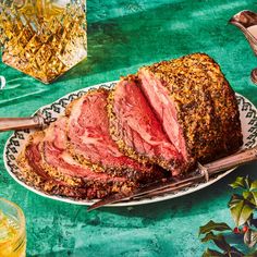 a meatloaf is sitting on a plate next to two glasses and a teapot