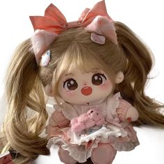 a doll with long blonde hair wearing a pink dress and holding a stuffed animal in her hands