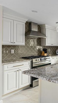 a kitchen with marble counter tops and white cabinets