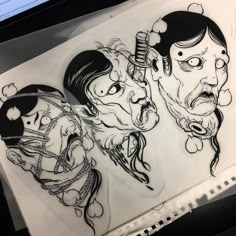 a drawing of two people with faces drawn in black and white on top of a piece of paper