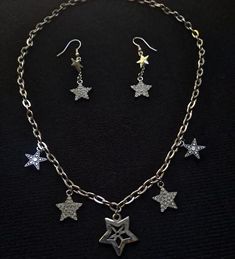 This one-of-a-kind jewelry set features eye-catching star charms that truly set them apart. This set contains the perfect accessories to enhance your outfit! Works well with any y2k style outfit. *Chain length is 19 1/2 inches Metal Star Charm Necklace In Star Shape, Star Shaped Metal Jewelry With Star Charm, Metal Star Charm Jewelry, Star-shaped Metal Jewelry With Dangling Charms, Y2k Style Outfits, Y2k Necklace, Star Charm Necklace, Y2k Jewelry, Star Charms